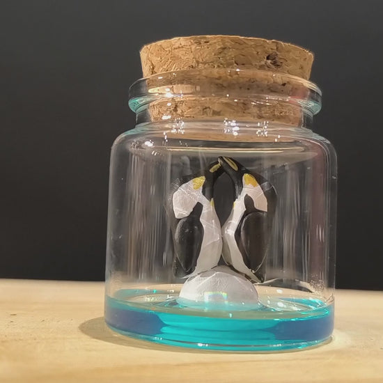 Figurines sculptées Manchots empereurs en parade  nuptiale dans petit flacon de verre. Modelées à la main en argile (pas de moulage) et peintes à la main. Sculpté dans mon atelier à Angers, France