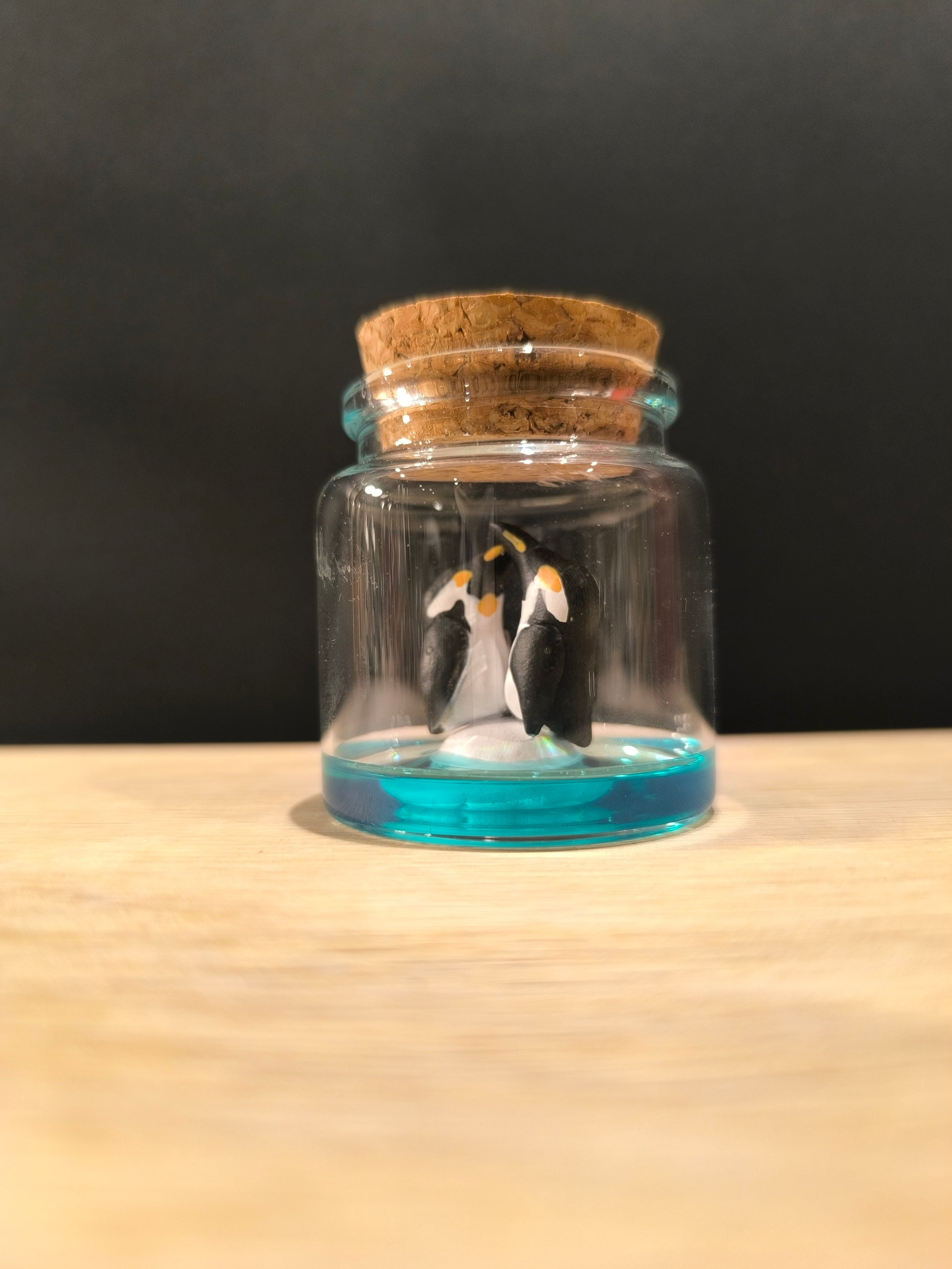 Figurines sculptées Manchots empereurs en parade  nuptiale dans petit flacon de verre. Modelées à la main en argile (pas de moulage) et peintes à la main. Sculpté dans mon atelier à Angers, France